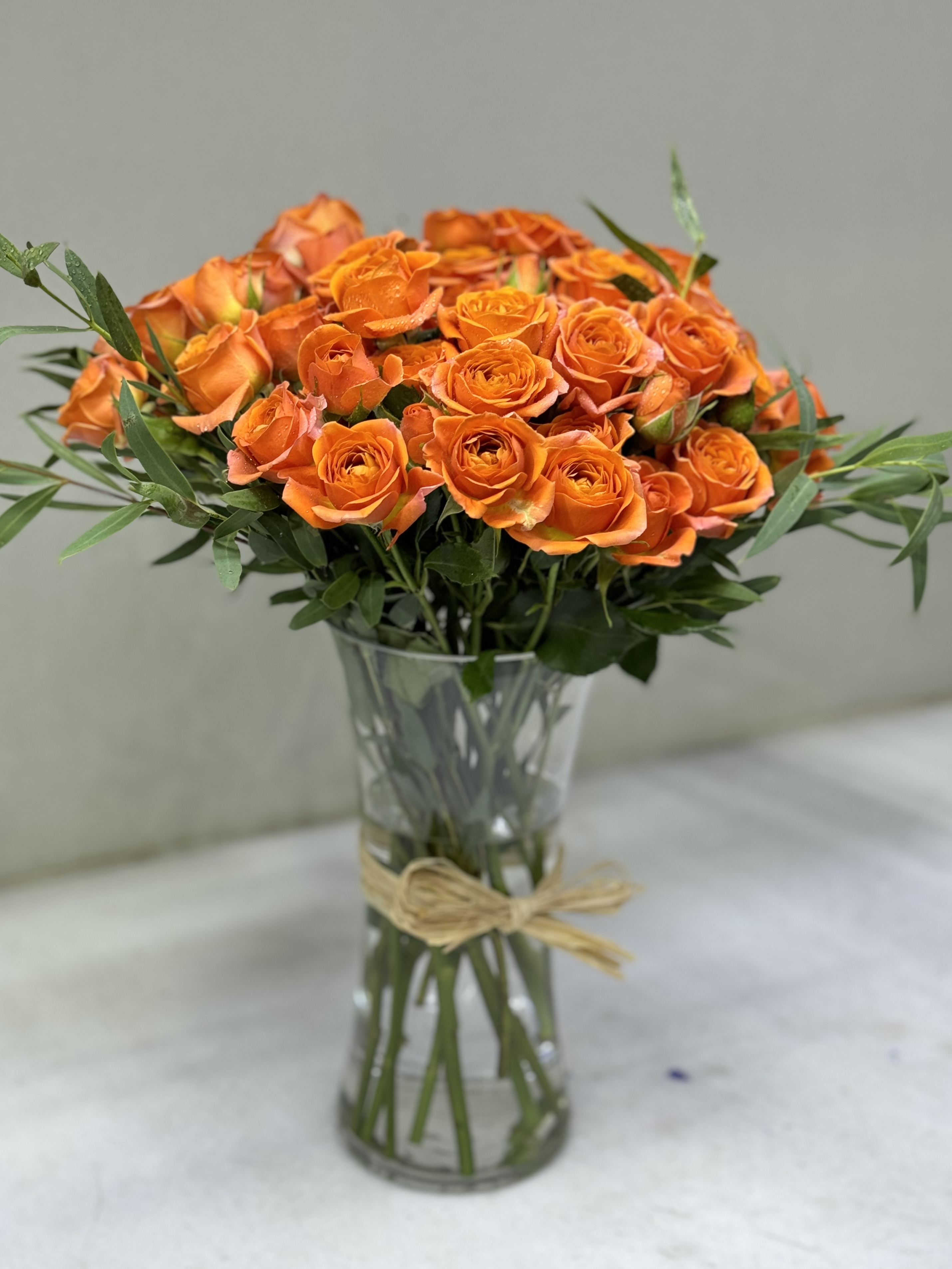 a bouquet of orange roses in a glass vase